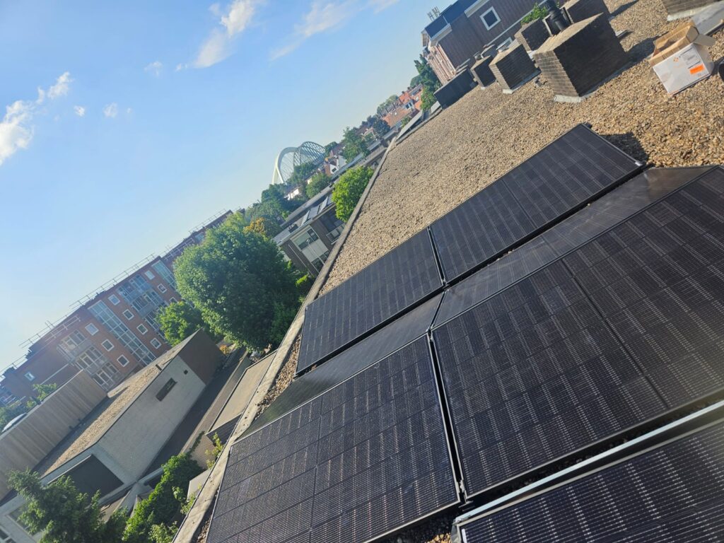 Rij zwarte zonnepanelen op een dak in Alphen, van bovenaf